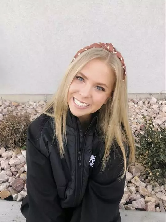 smiling woman in a hat with a beautiful straight smile she got in Cache Valley