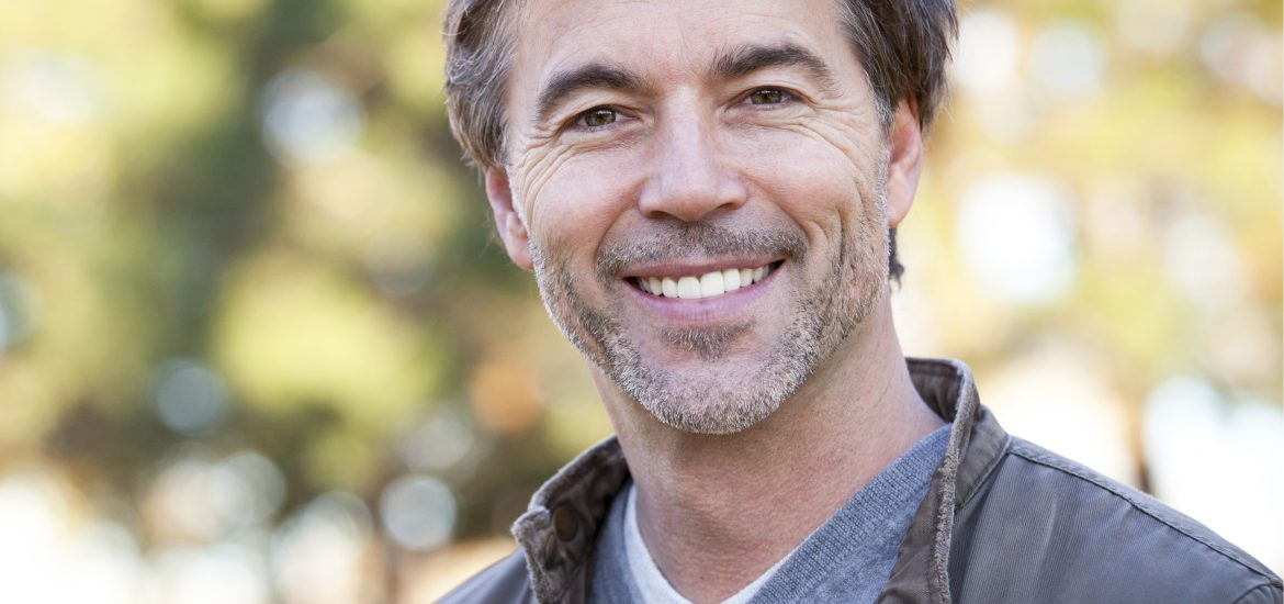 Middle aged man showing off his attractive straight white smile.
