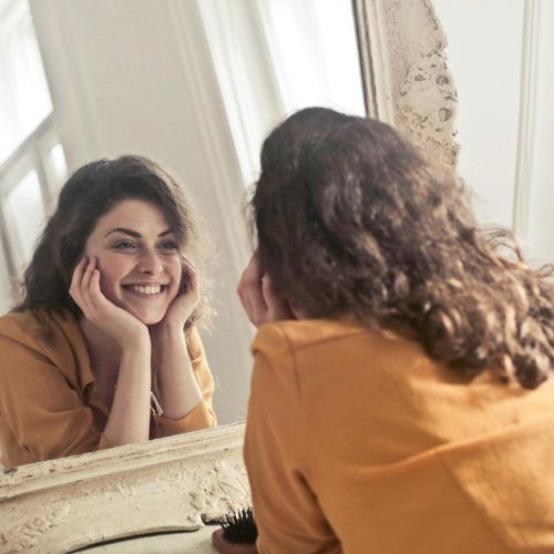 woman admires teeth after cosmetic dentistry treatments by Logan, UT cosmetic dentist