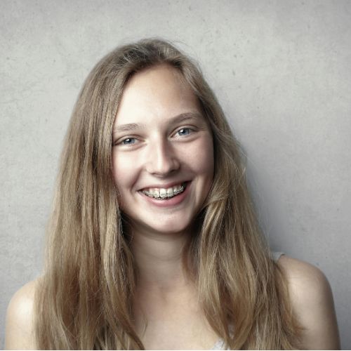woman showing off braces from Logan, UT orthodontist