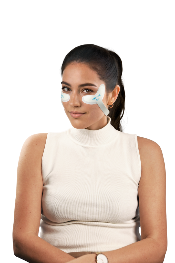 Patient wearing EMFACE applicators for facial aesthetics treatment
